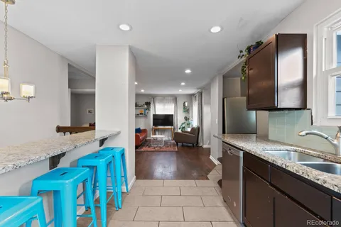 a large kitchen with stainless steel appliances kitchen island granite countertop a sink and cabinets