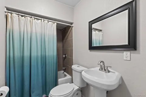 a bathroom with a toilet a sink and mirror