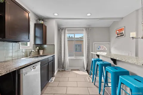 a kitchen with stainless steel appliances granite countertop a sink and a refrigerator
