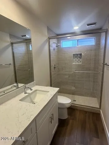 a bathroom with a sink a toilet a mirror and shower