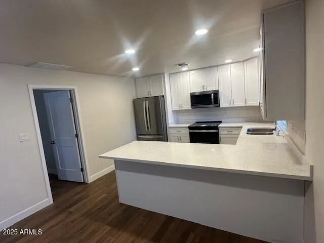 a kitchen with kitchen island white cabinets and refrigerator