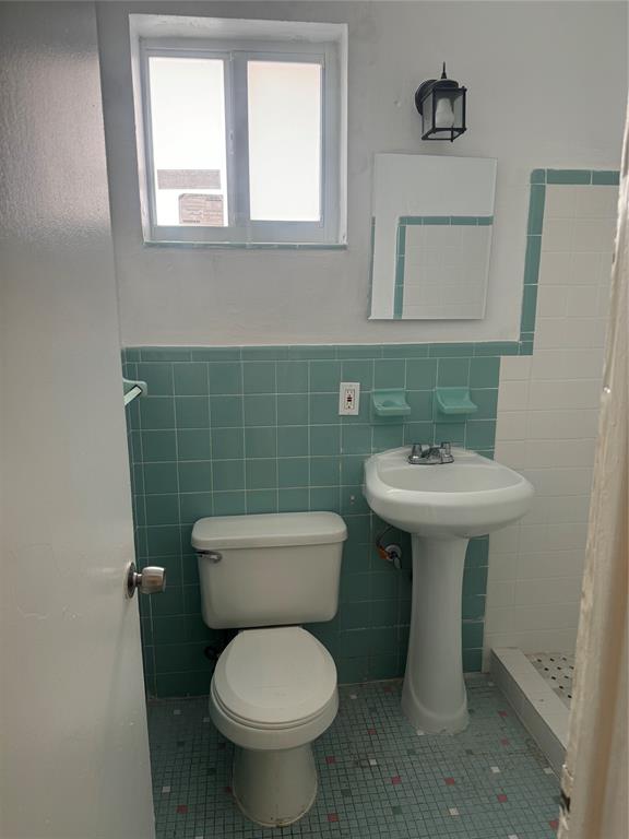 2986 Northwest 91st Street Miami, FL 33147 - Photo 9 of 40 a bathroom with a toilet sink and mirror