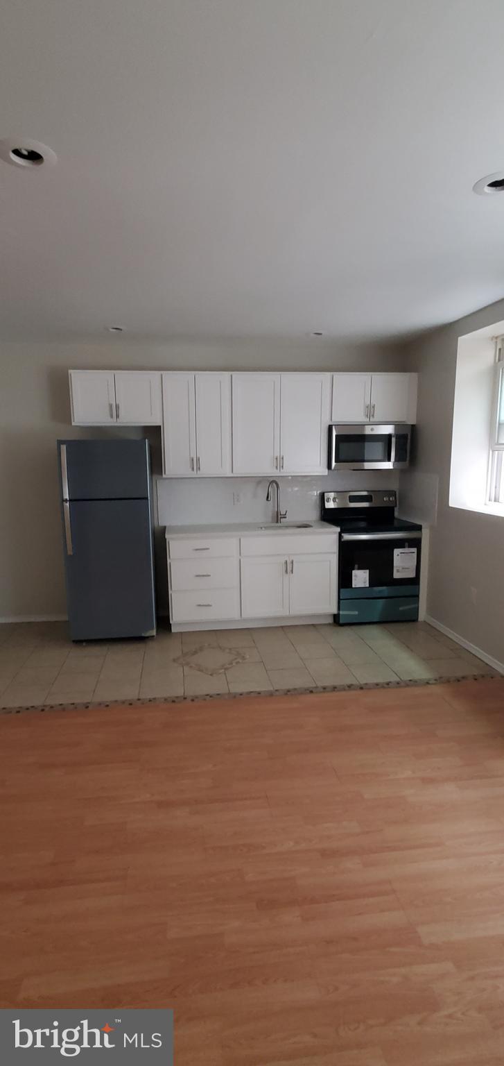 4728 Chestnut Street, Unit 3 Philadelphia, PA 19139 - Photo 1 of 1 a kitchen with a refrigerator and a stove