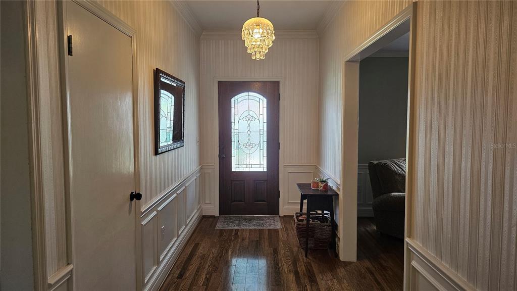 184 Lake Otis Road Winter Haven, FL 33884 - Photo 4 of 31 a view of a hallway with wooden floor and a chandelier