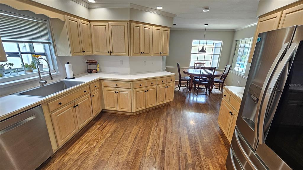 184 Lake Otis Road Winter Haven, FL 33884 - Photo 10 of 31 a kitchen with stainless steel appliances granite countertop a refrigerator a sink dishwasher a stove and white countertops with wooden floor