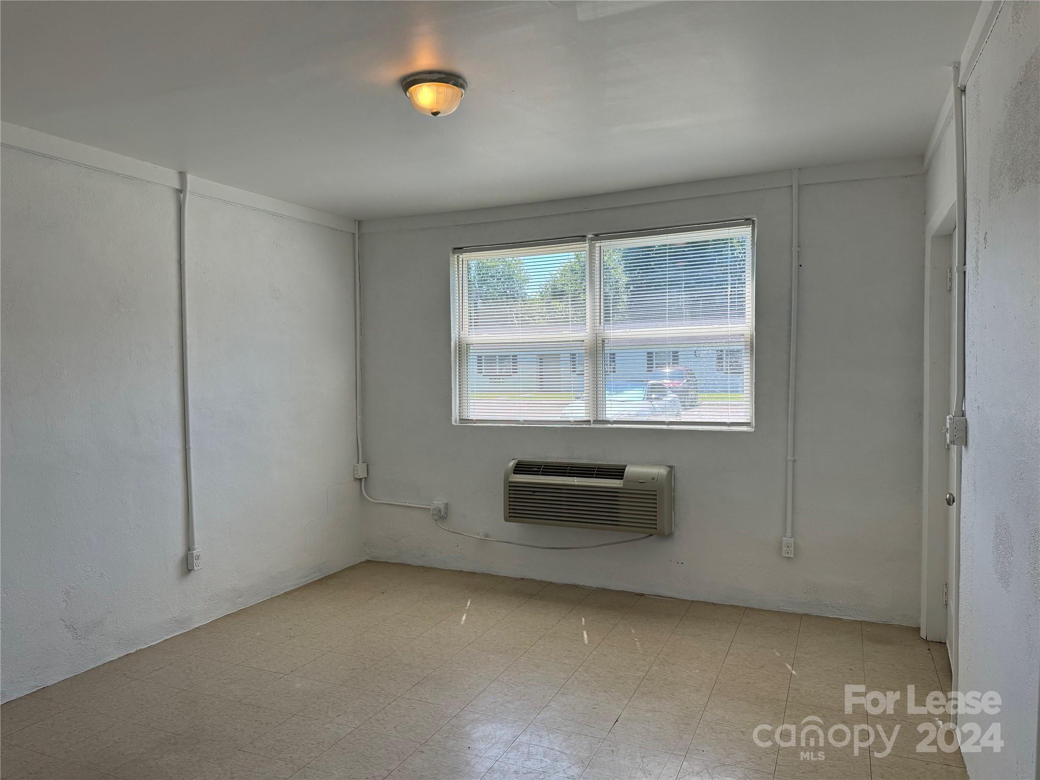 200 York Street, Unit E2 Chester, SC 29706 - Photo 4 of 15 an empty room with cabinet and windows