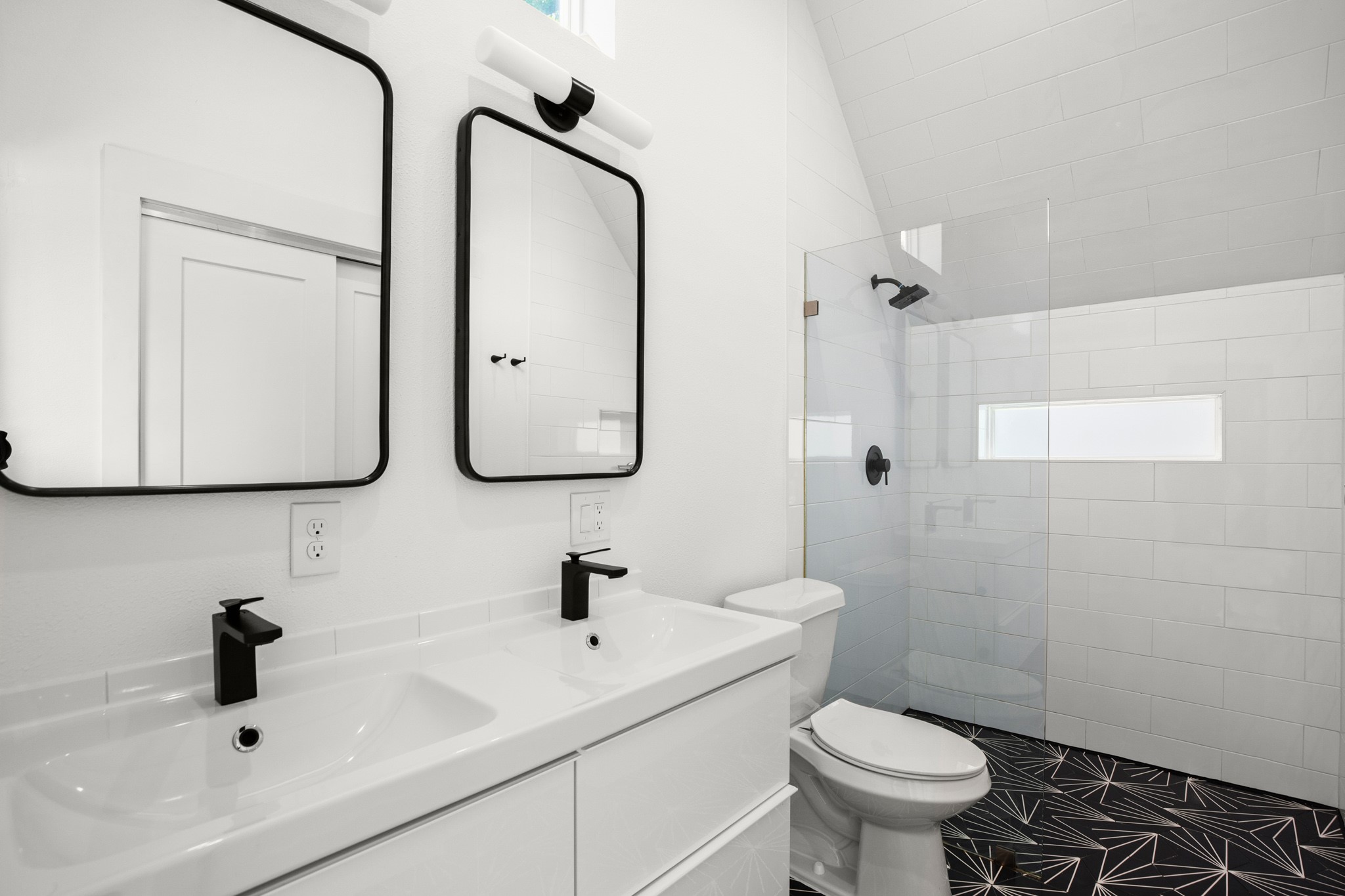 4608 Santa Anna Street, Unit 1 Austin, TX 78721 - Photo 29 of 35 Primary ensuite bathroom with updated tiling, a walk-in shower, dual vanity, and the second primary closet with built-in shelving.