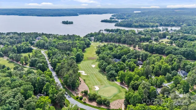 an aerial view of a house with a yard and lake view