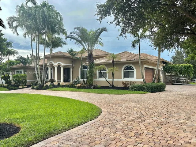 a front view of a house with a garden and yard