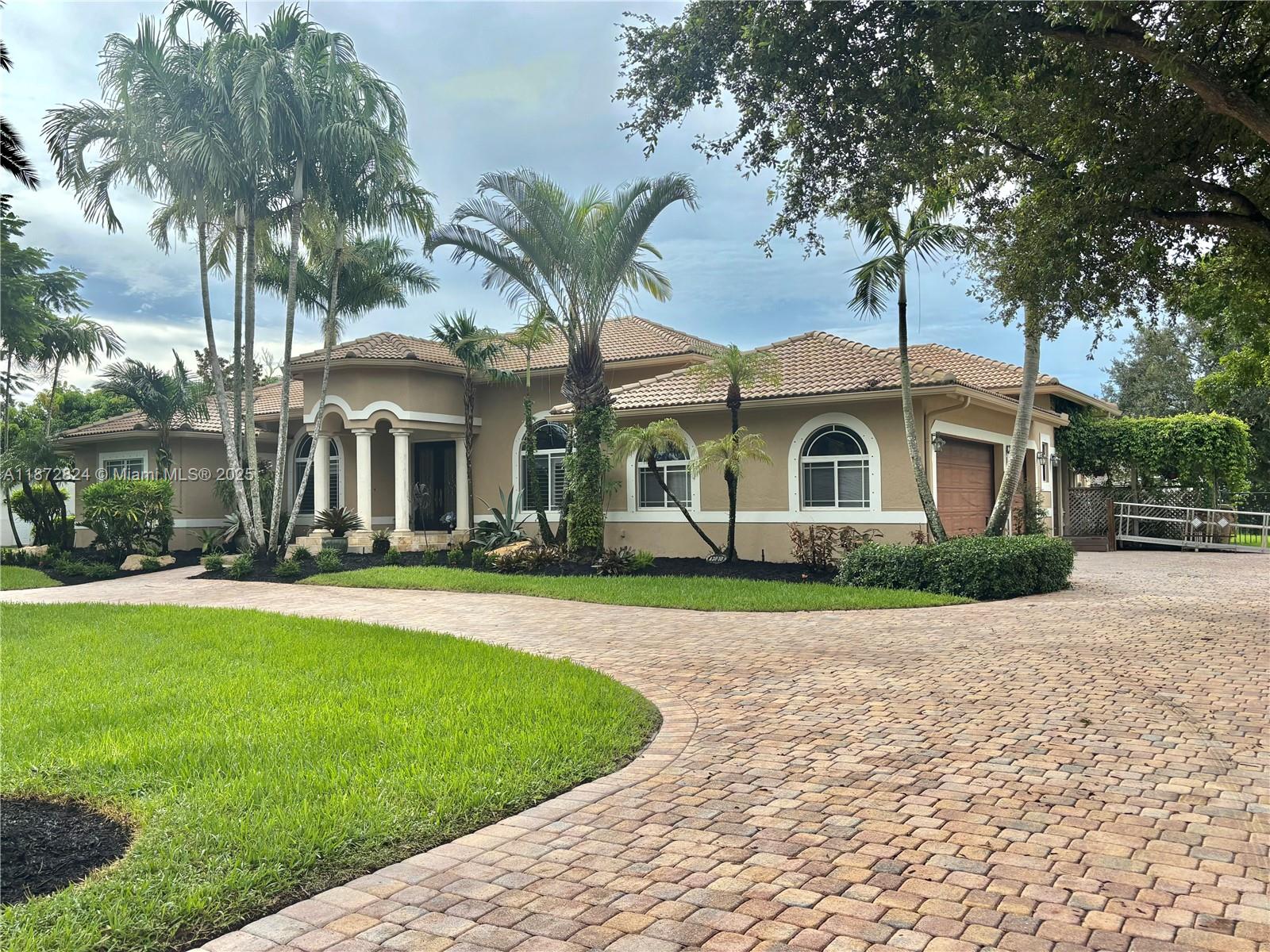 13040 Southwest 30th Court Davie, FL 33330 - Photo 2 of 42 a front view of a house with a garden and yard