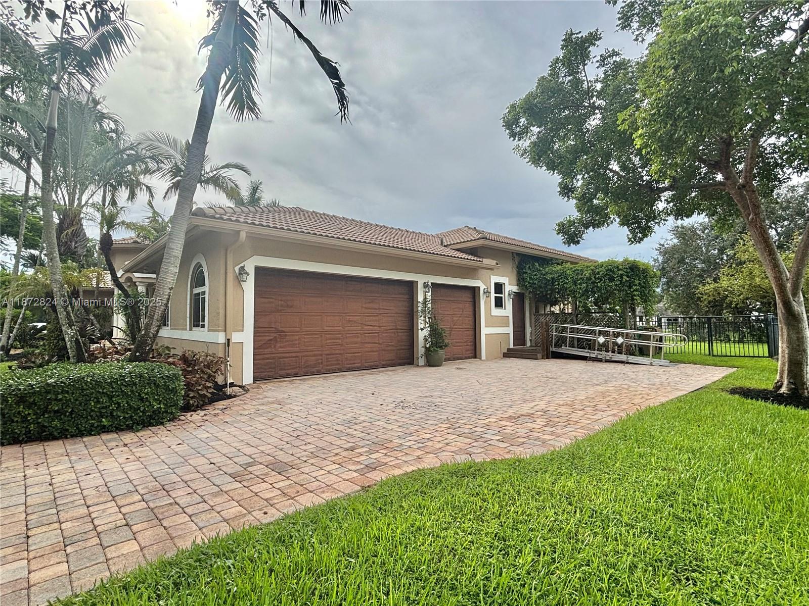 13040 Southwest 30th Court Davie, FL 33330 - Photo 4 of 42 a front view of a house with a yard and garage