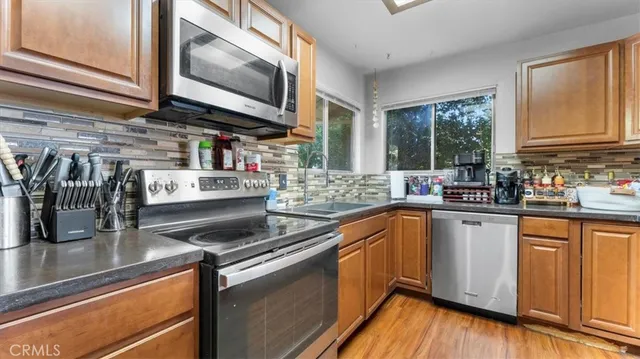 a kitchen with stainless steel appliances granite countertop a sink a stove and cabinets