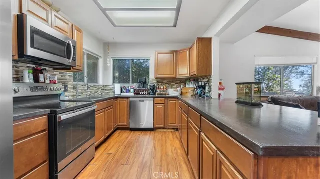 a kitchen with stainless steel appliances granite countertop a sink stove microwave and cabinets