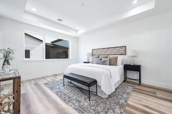a bedroom with a bed and a potted plant on dresser