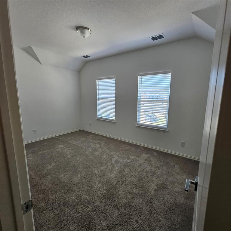 2309 Jack Rabbit Way Northlake, TX 76247 - Photo 20 of 28 Carpeted room featuring two windows with horizontal blinds, white walls, and a vaulted ceiling with a flush-mount light fixture
