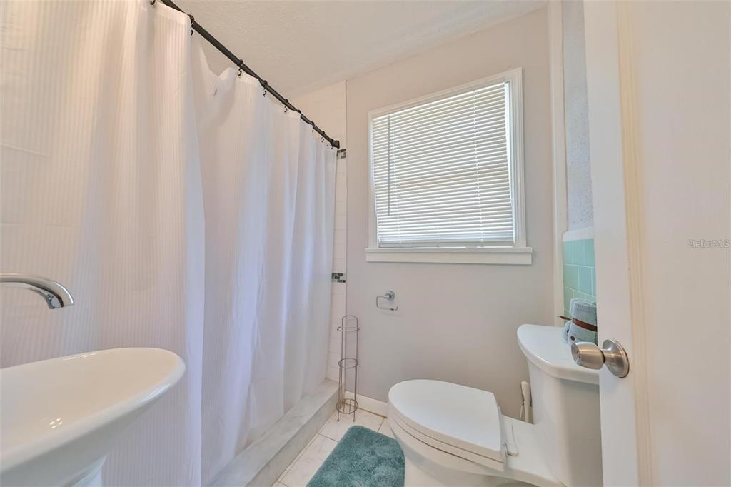 5117 North Rome Avenue Tampa, FL 33603 - Photo 6 of 9 a bathroom with a sink a toilet a mirror and shower