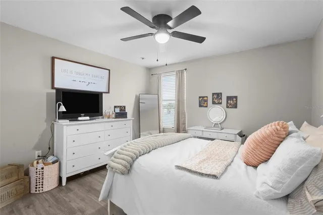 a bedroom with a bed a flat screen tv and dresser