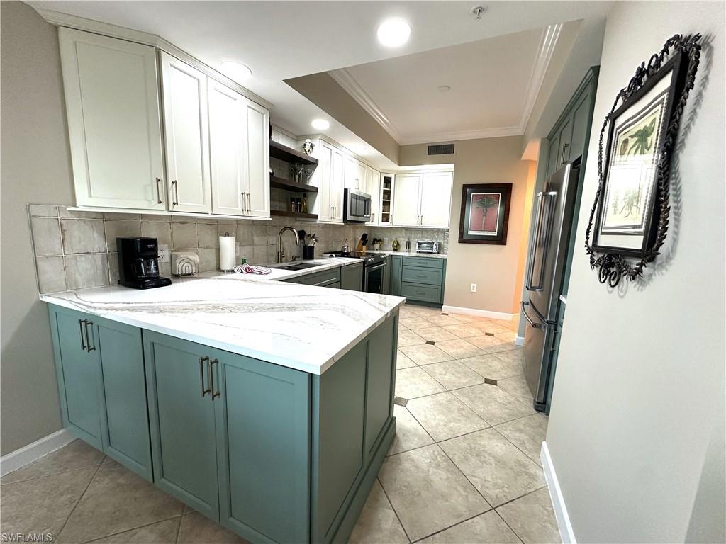 325 Dunes Boulevard, Unit 306 Naples, FL 34110 - Photo 10 of 40 a kitchen with a sink a refrigerator and cabinets