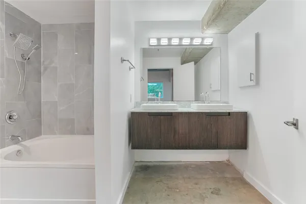 a bathroom with a bathtub a mirror a vanity and a shower