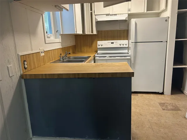 a kitchen with a sink a refrigerator and cabinets