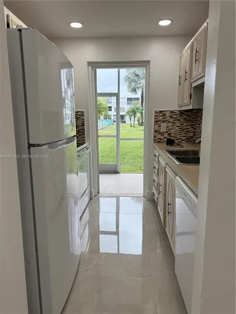 a kitchen with a refrigerator a stove and a sink