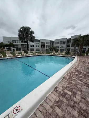 a view of a swimming pool with outdoor seating and plants