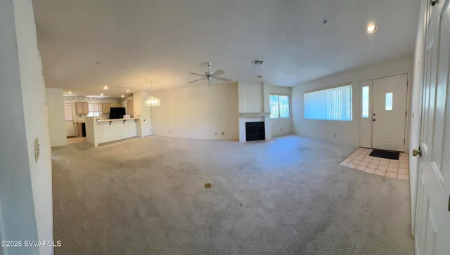 an empty room with a kitchen and a window