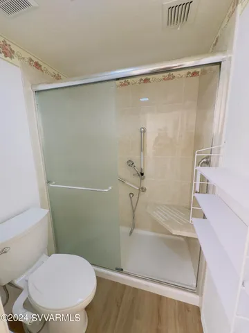 a bathroom with a toilet and a shower