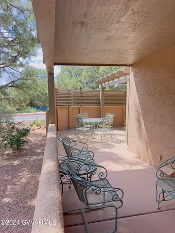 a view of a patio with table and chairs next to a yard
