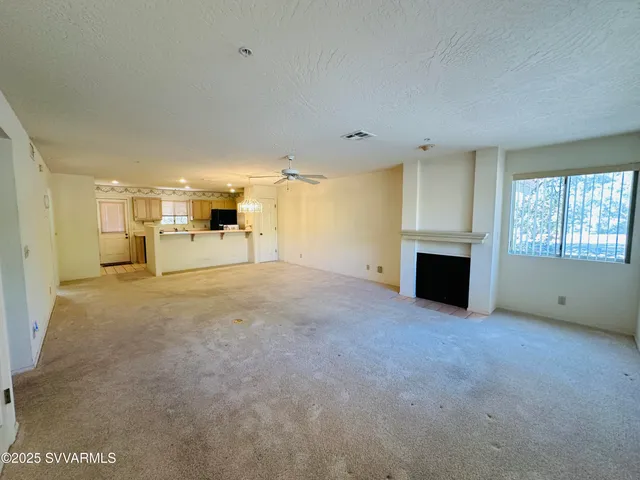 a view of empty room with a fireplace and a window