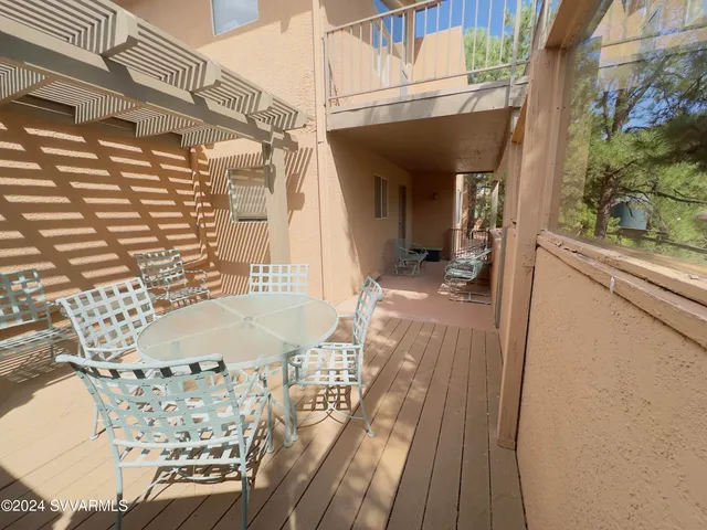 a view of a balcony with wooden floor and furniture