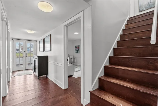 a view of a hallway with wooden floor and staircase