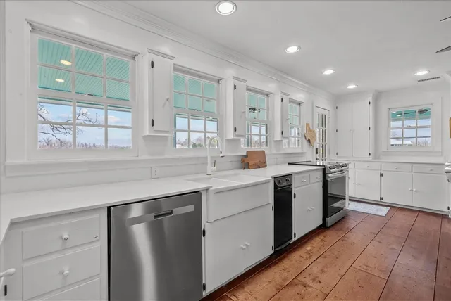 a kitchen with white cabinets and sink