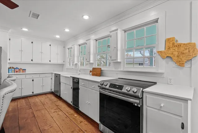 a kitchen with a stove and white cabinets