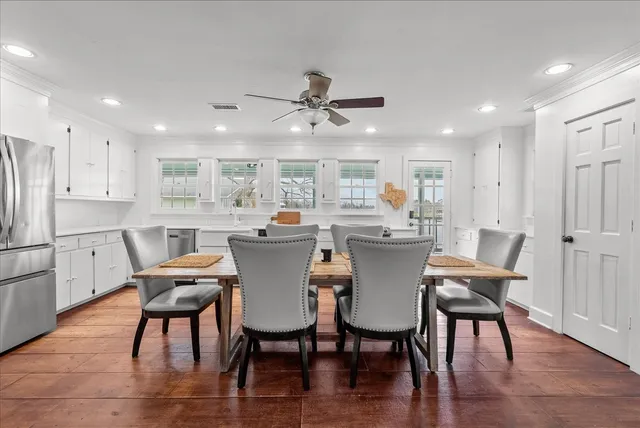 a view of a dining room with furniture a rug and wooden floor