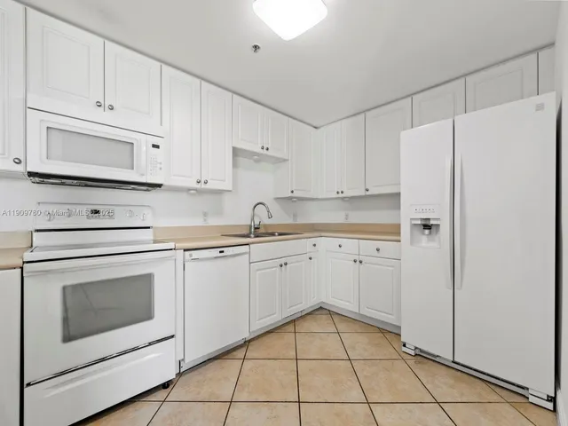 a kitchen with white cabinets and white appliances