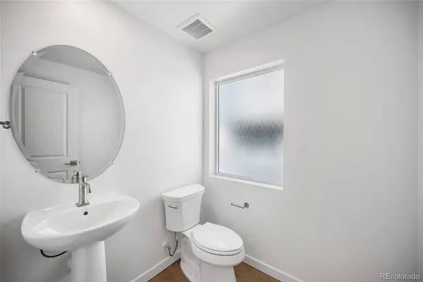 a bathroom with a toilet a sink and mirror