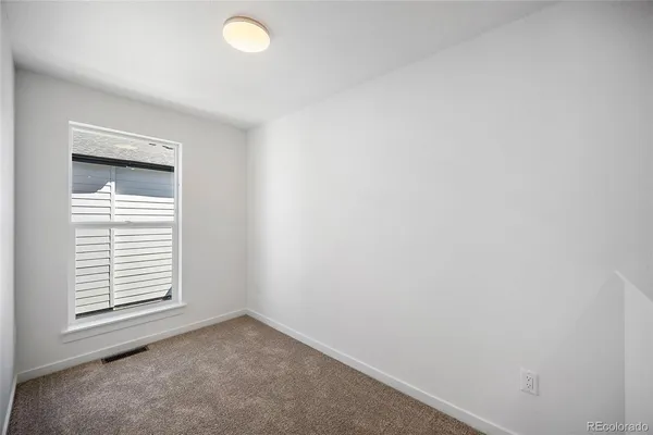 an empty room with windows and closet