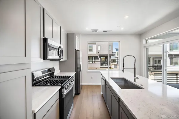 a kitchen with stainless steel appliances granite countertop a sink stove and cabinets
