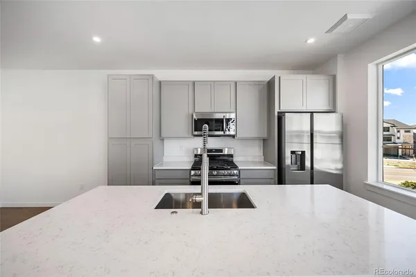 a kitchen with stainless steel appliances a refrigerator and a stove top oven
