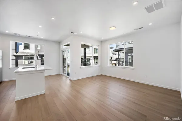 a view of an empty room with window and wooden floor