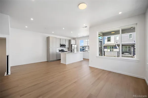 a view of a kitchen with wooden floor and windows