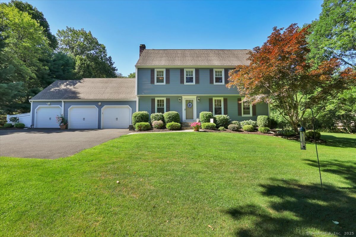 a front view of a house with a yard and trees