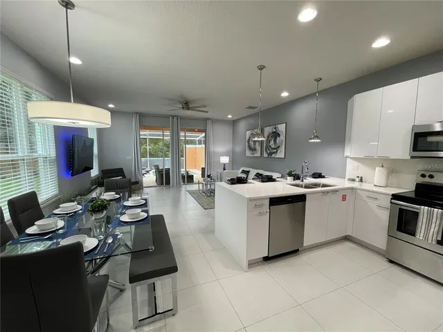a kitchen with kitchen island granite countertop a sink counter top space appliances and cabinets