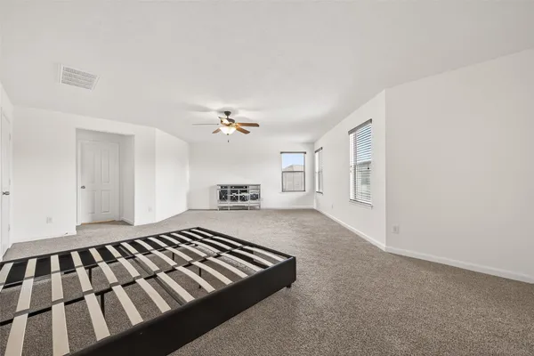 a spacious bedroom with a bed and a chandelier
