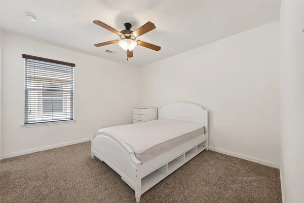 a bed sitting in a bedroom next to a window