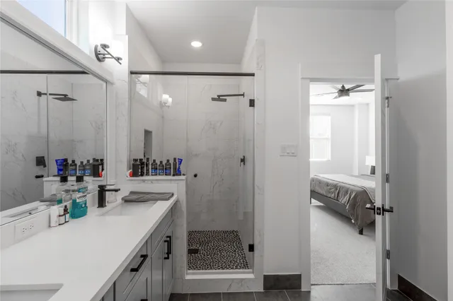 a bathroom with a double vanity sink mirror and shower