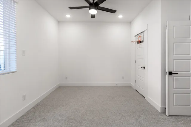 an empty room with a ceiling fan and a window