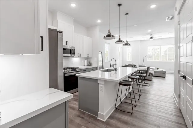 a kitchen with a sink a stove a refrigerator and chairs