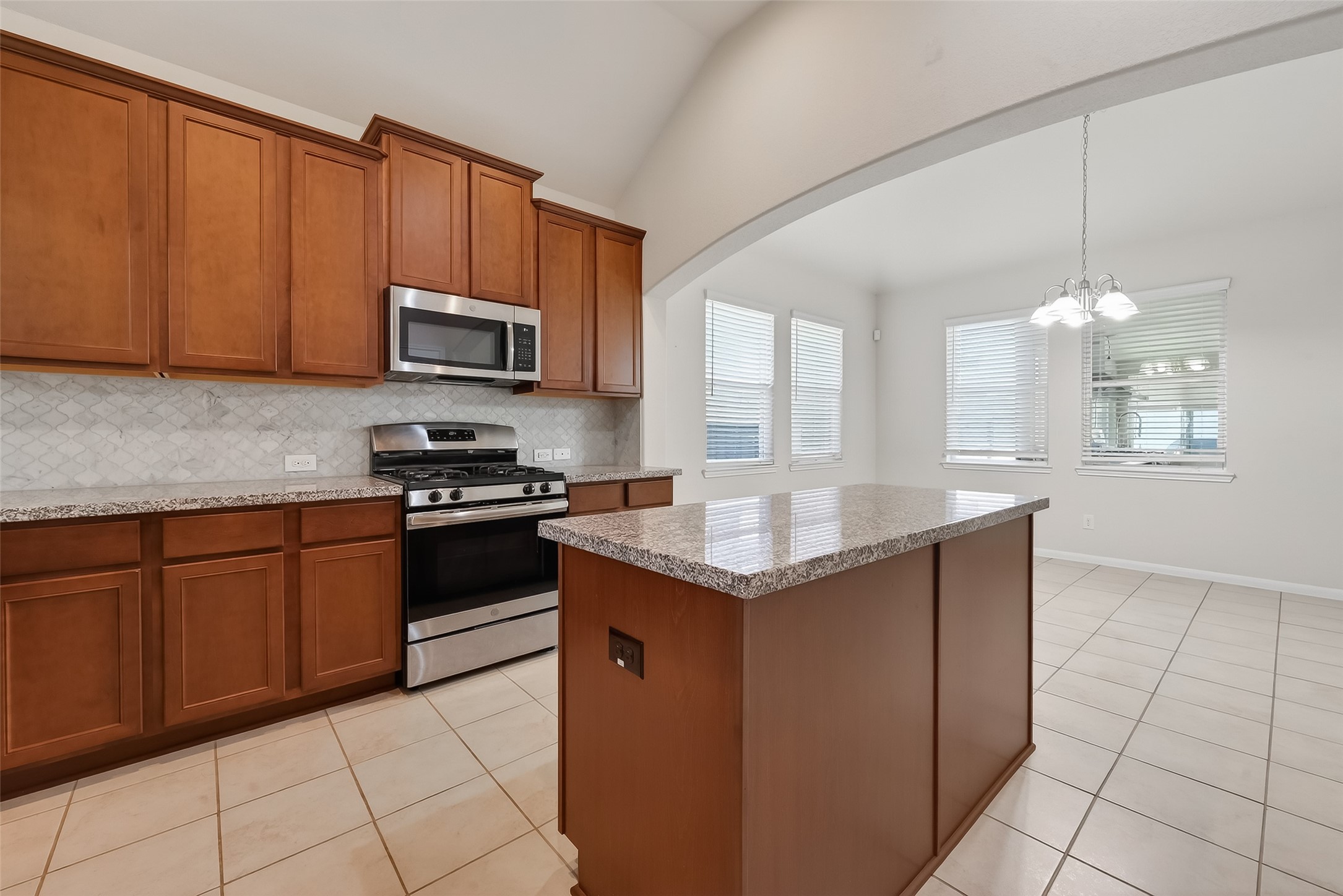 7631 Granite Terrace Lane Houston, TX 77083 - Photo 17 of 46 Features a gas stove, double sink, and wooden cabinetry, perfect for a functional and inviting cooking space.